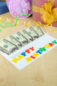 美元的信封作为在木桌特写的生日礼物