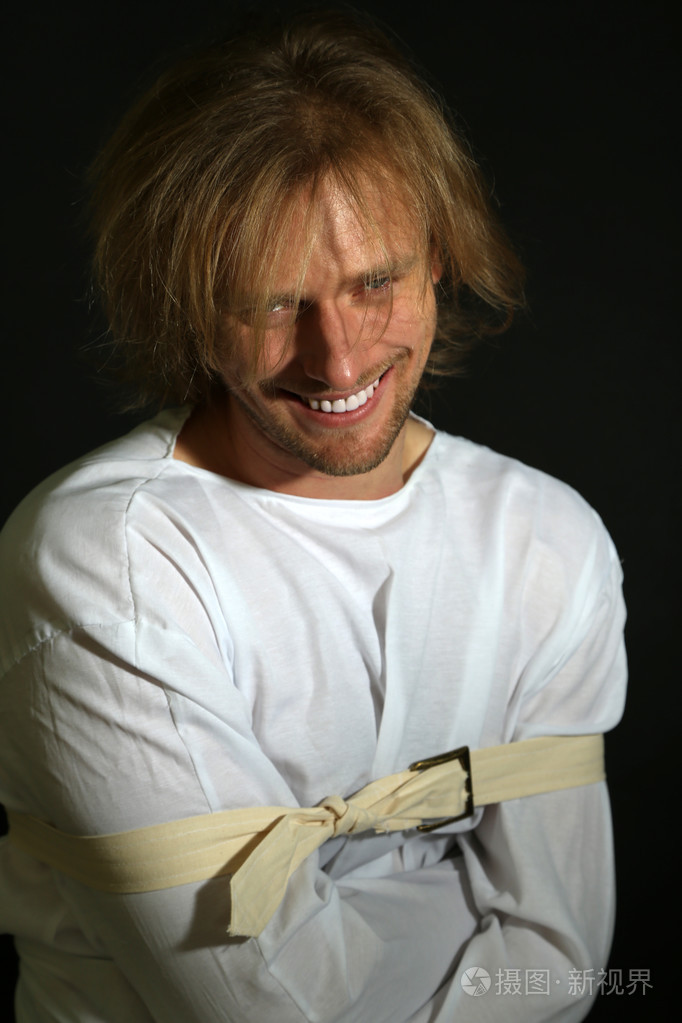 精神病的男子在黑色背景上的海峡夹克