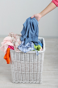 完整的洗衣篮，在灰色的背景上的女人