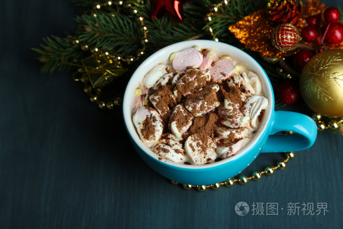 热巧克力奶油在颜色的杯子里，在桌子上，圣诞装饰品背景