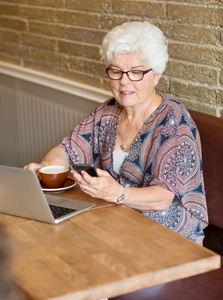 女子短信通过智能手机在咖啡馆