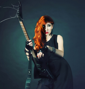 红头发的女孩与黑色的吉他图片