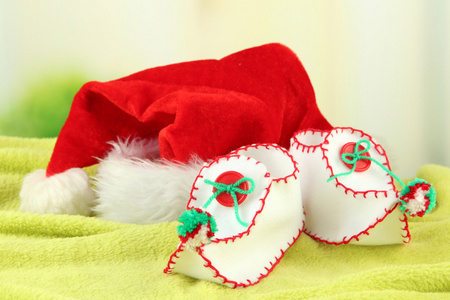与圣诞老人的帽子，在织物上明亮的背景上的装饰圣诞鞋。
