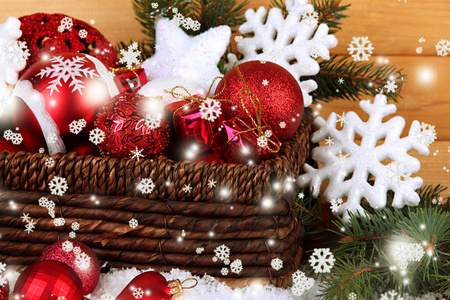 圣诞装饰品在篮子里的雪上木制背景表格