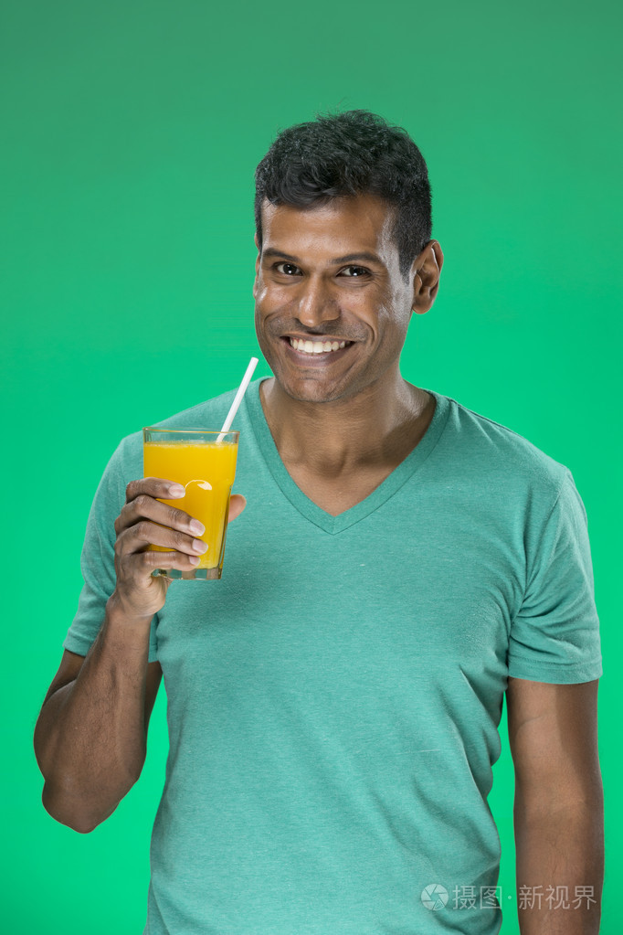 快乐的印度裔男子喝橙汁