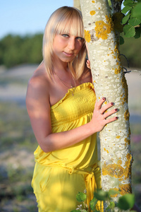 美丽的金发女郎，一棵树旁