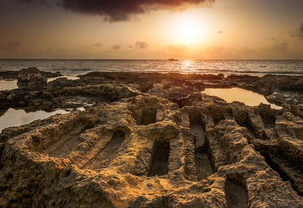 海和岩石海岸，与古代遗址上空的日落