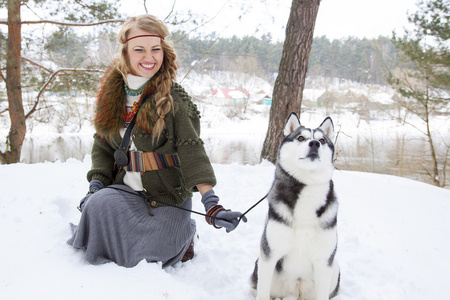 快乐的年轻女人坐着西伯利亚爱斯基摩狗