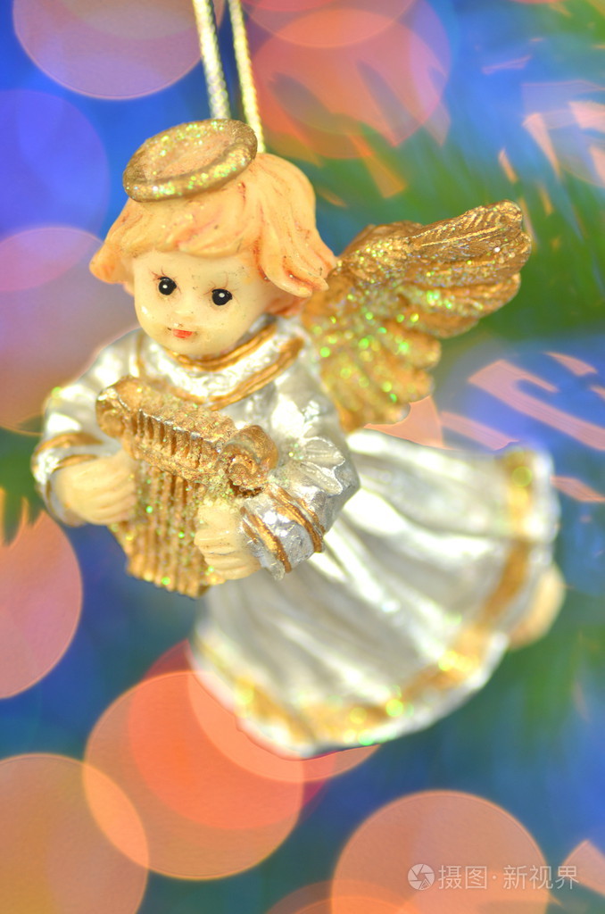 圣诞节装饰物,弹奏着竖琴在景背景下的小天使图