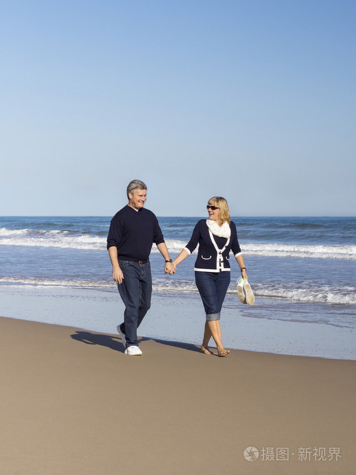 ldre par promenader lngs stranden嬉戏成熟夫妻沿着海滩散步