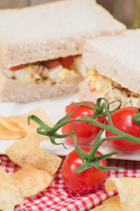 新鲜鸡蛋和番茄对白色三明治在乡村厨房设置
