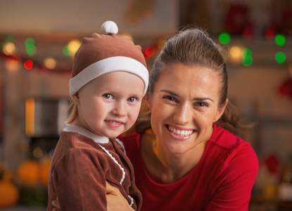 微笑母亲和婴儿在圣诞节装饰厨房