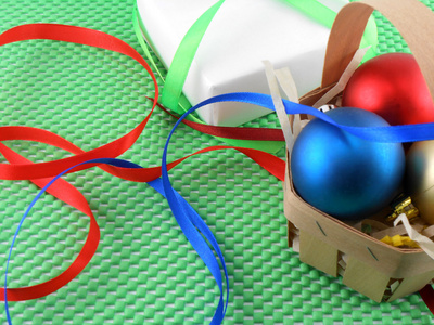 圣诞球和绿色背景上的白色礼品盒