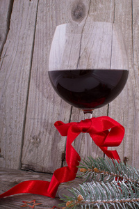 红葡萄酒杯与圣诞装饰木制的桌子上