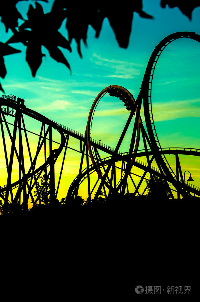 新的主题公园和娱乐公园.在集市上的过山车的剪影