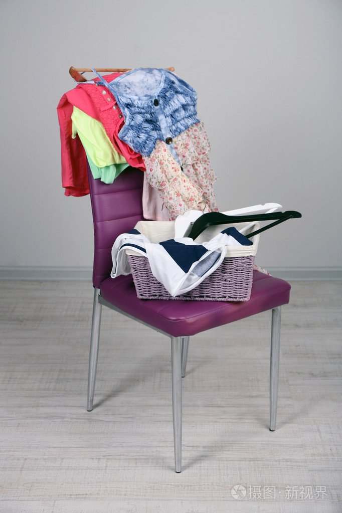 堆衣服在颜色的椅子上在灰色的背景上