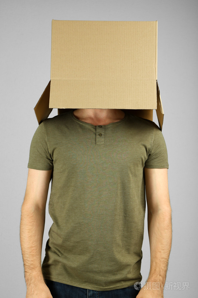 他头上灰色的背景上的纸板箱的男人