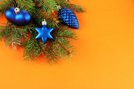 在橘黄色的背景上的枞树上的美丽圣诞装饰品。