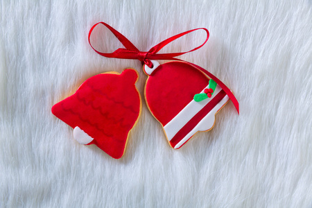 圣诞饼干红色的铃形状和白色的皮毛上丝带