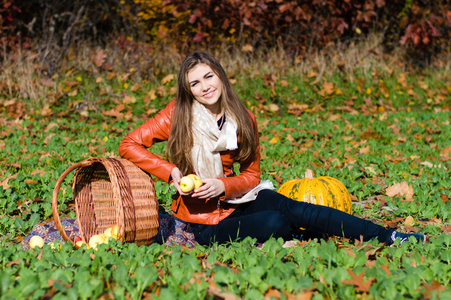 幸福的年轻女人，提着篮子新鲜的苹果