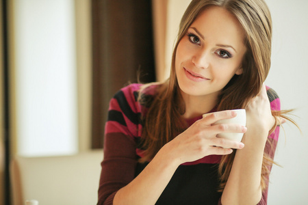 年轻漂亮的女人，坐在一个咖啡馆，一杯茶