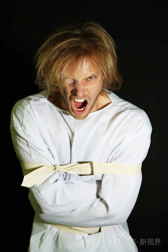 精神病的男子在黑色背景上的海峡夹克