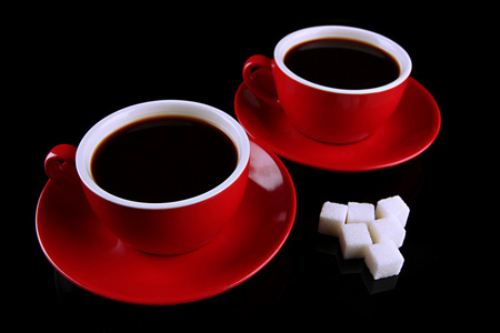红杯浓咖啡和糖上黑色孤立