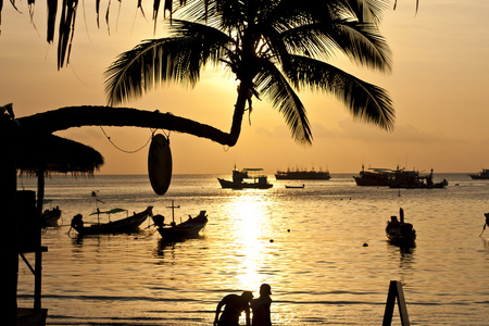 夕阳与棕榈和热带海滩上的小船。柯陶岛
