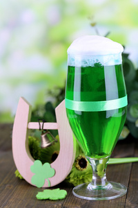 杯绿色的啤酒和马蹄为圣帕特里克节在木桌特写