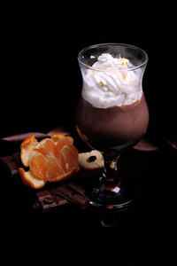 美味的甜点，巧克力，奶油色和橙色的酱，在深色背景上