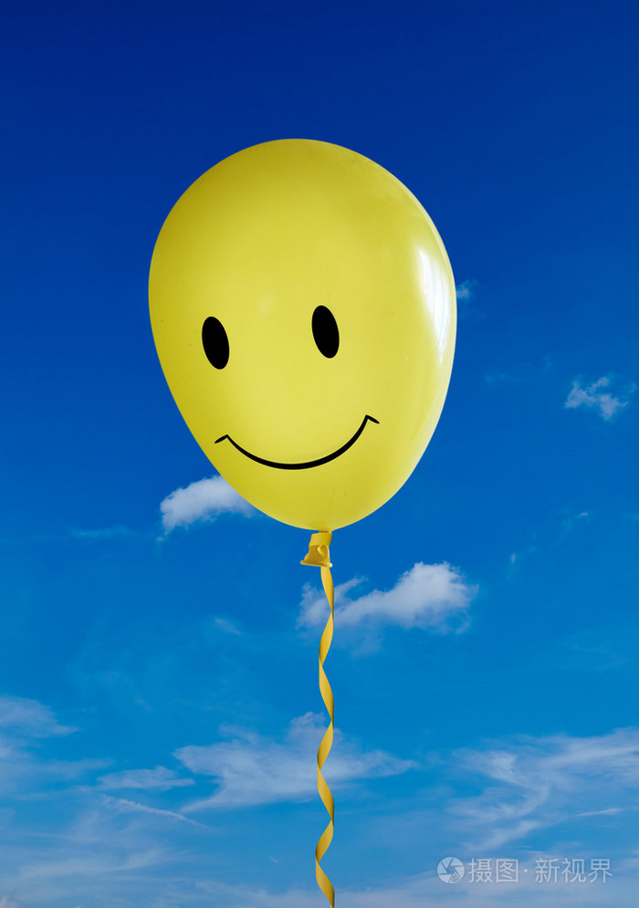 黄色的笑脸气球在湛蓝的天空