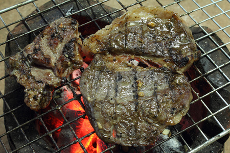 在火炉上用烤盘上烤鸡胸肉图片