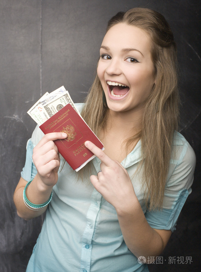 可爱的小女孩学生用钱和护照的肖像