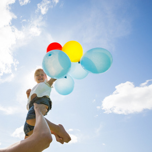 母亲解除女儿控股气球多云的天空