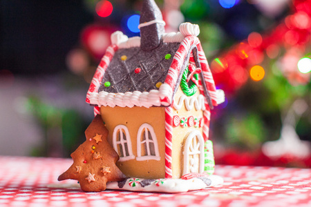 装饰明亮的圣诞树花环与背景上的甜蜜糖果的姜饼屋