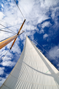 帆船游艇桅杆与白帆反对暗蓝的天空