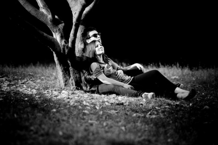 白之恋人爱躺在公园的大树下拥抱的照片