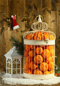 橘子装饰圣诞装饰，木制的背景上的笼子里