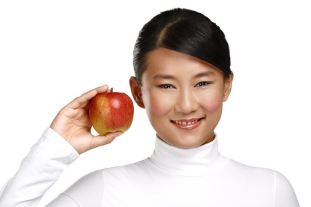 年轻漂亮的亚洲女人吃一个苹果