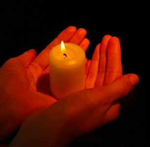 黑色的预兆燃烧的蜡烛,在手上黑色孤立照片