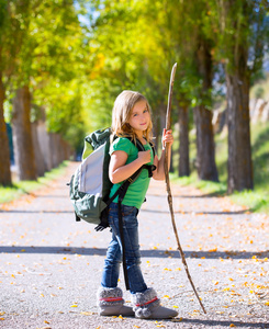 金发碧眼的资源管理器中孩子们女孩走在秋天的树木，背包里