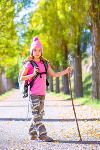 孩子们女孩手杖和在秋天背包徒步旅行