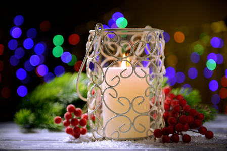 在明亮的背景背景上木制的桌子上的蜡烛，圣诞树芽
