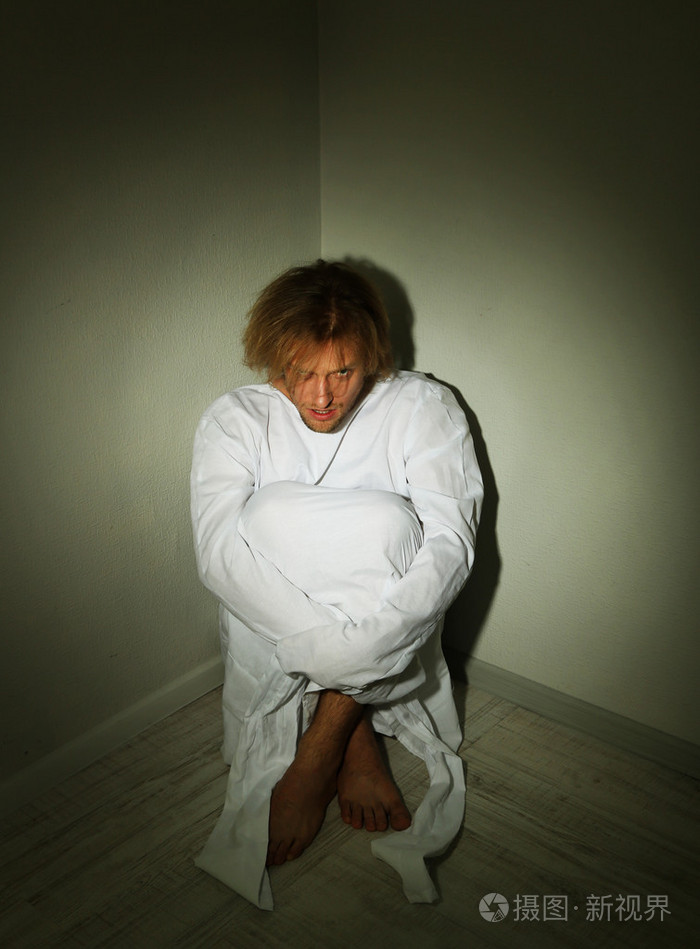 精神病在房间角落里的海峡夹克的男子