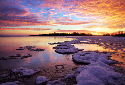 冬季景观与湖和日落火红的天空
