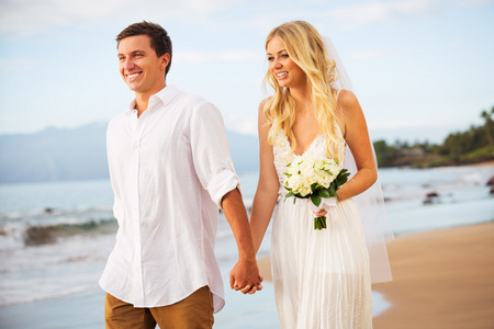 海滩上散步，在日落时分的只是已婚的夫妇
