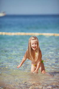 坐在海边沙滩上的小女孩