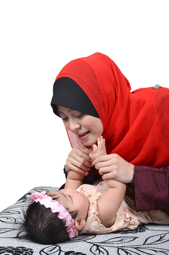 年轻的亚洲穆斯林母亲玩,带上白色背景孤立她可爱的小宝贝女孩微笑