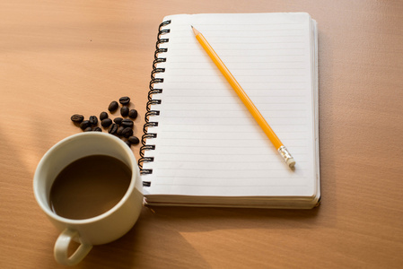 木制背景上空白笔记本咖啡杯子