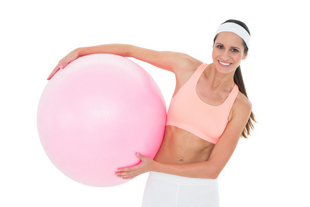 一个微笑的适合女人牵着健身球的肖像